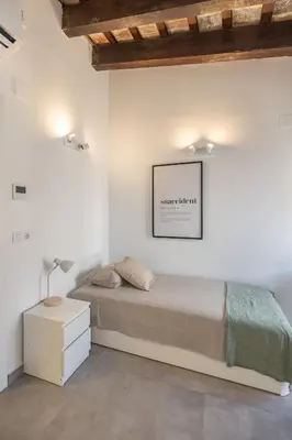 a white bedroom with a bed and a lamp at Residencia Universitaria Trinitarios in Valencia