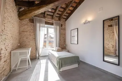 a bedroom with a bed and a table and a window at Residencia Universitaria Trinitarios in Valencia