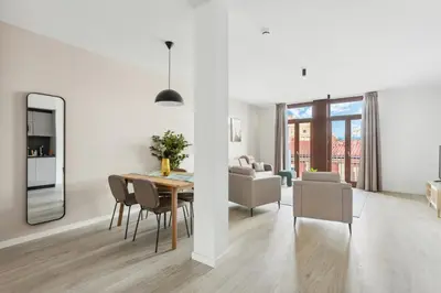 a dining room and living room with a table and chairs at Limehome Valencia Calle de Cadiz in Valencia