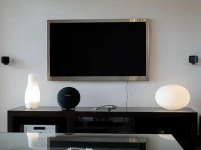 a flat screen tv on a wall with two lamps at Casa Chalet Villa con piscina, jardín y aire acondicionado cerca de Valencia en La Eliana-L'Eliana in La Eliana