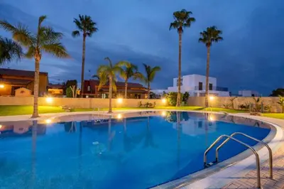 a large swimming pool at night with palm trees at Holiday Home Valencia in Riba-Roja De Turia