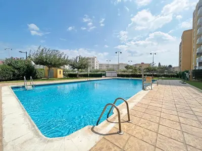 a large swimming pool with blue water in a building at Global Vacacional, Apartamento con piscina y terraza en Canet in Canet de Berenguer