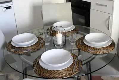 a glass table with plates and a candle on it at Piso Cerca Universidades y de la Playa in Valencia