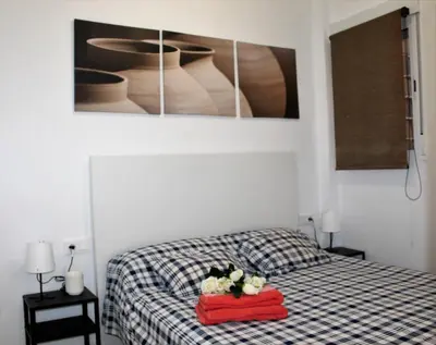 a bedroom with a bed with a red blanket and flowers on it at Piso Cerca Universidades y de la Playa in Valencia