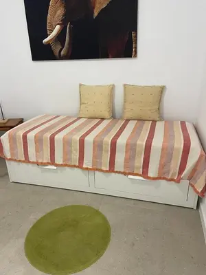 a bed with two pillows and a painting on the wall at Piso Cerca Universidades y de la Playa in Valencia