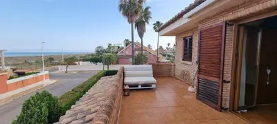 a patio with a bench and a view of the ocean at Casa en la playa in Sagunto