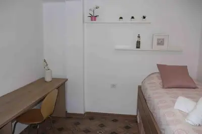 a small bedroom with a desk and a bed at Precioso apartamento con vistas al mar. Piscina. in Valencia
