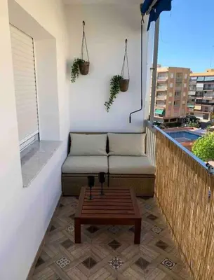 a patio with a couch and a table on a balcony at Precioso apartamento con vistas al mar. Piscina. in Valencia