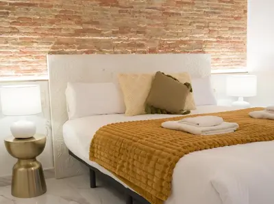 a bedroom with a large white bed with two lamps at Central Market - Ciutat Vella, exclusively for families - Mid-term in Valencia
