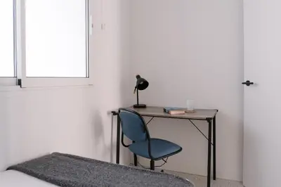 a desk with a blue chair next to a window at La Alfarería in Valencia