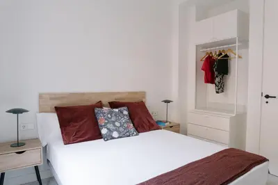a bedroom with a white bed with red pillows at La Alfarería in Valencia