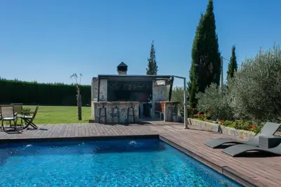 a house with a swimming pool next to a wooden deck at La Traviesa,Villa de Lujo de 500 m. en el Campo con Piscina in Campo Arcís