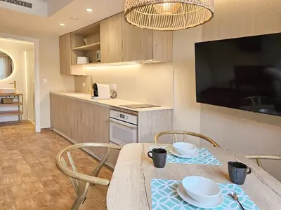 a kitchen with a table and chairs and a television at Apartamentos Las Ciencias Studio Q in Valencia