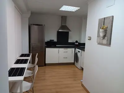 a kitchen with a table and a refrigerator at Alojamiento Temporal para Familias, Turismo, Estudiantes y Trabajo 