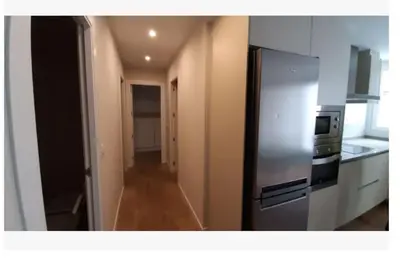 a kitchen with a stainless steel refrigerator and a hallway at Apartamento WELCOME céntrico de diseño en calle Tres Forques in Valencia