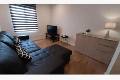 a living room with a black couch and a television at Apartamento WELCOME céntrico de diseño en calle Tres Forques in Valencia
