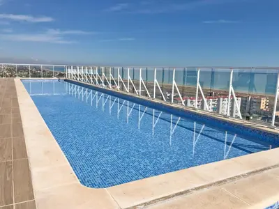 a swimming pool on the roof of a building at Global Vacacional, Moderno apartamento con piscina en la playa de Canet in Canet de Berenguer