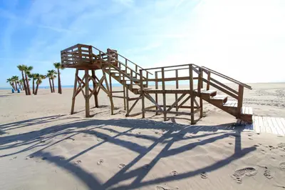 a wooden life guard station on the beach at Global Vacacional, Moderno apartamento con piscina en la playa de Canet in Canet de Berenguer