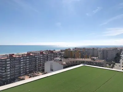 a green lawn on the roof of a building at Global Vacacional, Moderno apartamento con piscina en la playa de Canet in Canet de Berenguer