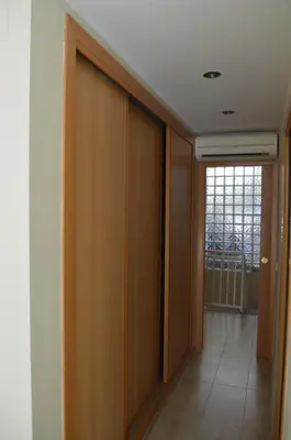 a hallway with wooden doors and a hallway with a window at Barraca Beach in Valencia