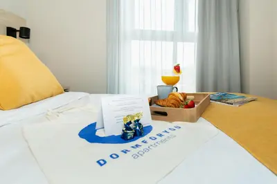 a bed with a box of bread and a drink on it at Dorm4You Arena 2 in Valencia