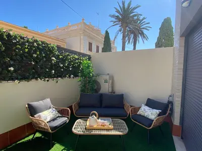 a patio with chairs and a table and a fence at Malvarrosa Playa en Valencia in Valencia