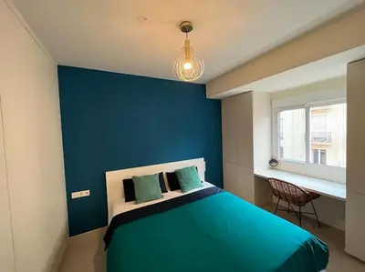 a blue bedroom with a bed with a blue wall at Modern apartment in heart of city in Valencia