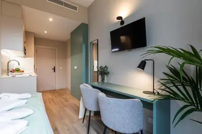 a room with a desk and chairs and a kitchen at Moontels Mercado de Ruzafa in Valencia
