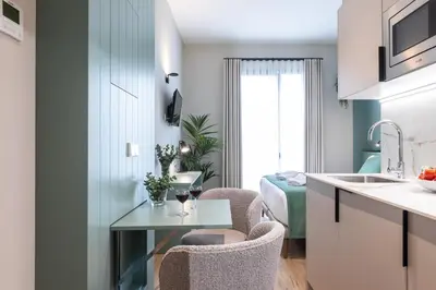 a kitchen with two chairs and a table in a room at Moontels Mercado de Ruzafa in Valencia