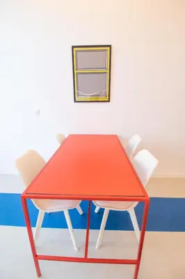 a red table and two white chairs in a room at Marino by Concept in Valencia