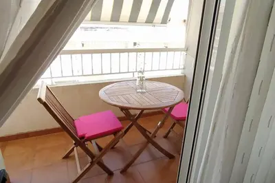 a table and two pink chairs in front of a window at Precioso apartamento en Canet d,en Berenger in Canet de Berenguer