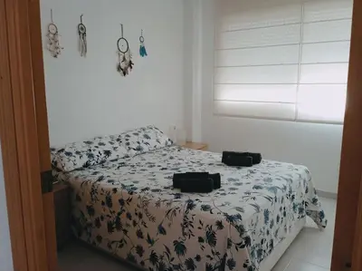 a bedroom with a bed with a blue and white comforter at Precioso apartamento en Canet d,en Berenger in Canet de Berenguer