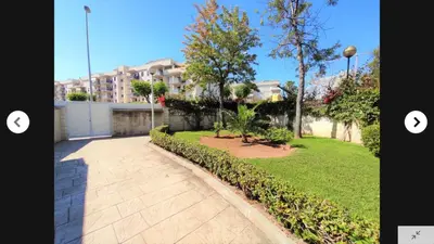 a walkway in a yard with a building in the background at CANET PLAYA MAGNIFICO APTO FAMILIAR con PISCINA y GARAJE in Canet de Berenguer
