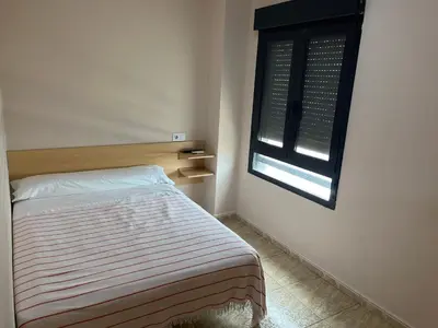 a small bedroom with a bed and a window at Hostal Restaurant El Poligono in Valencia