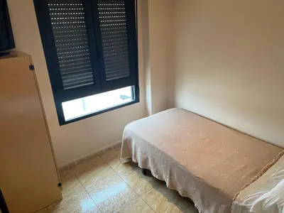a small bedroom with a bed and a window at Hostal Restaurant El Poligono in Valencia