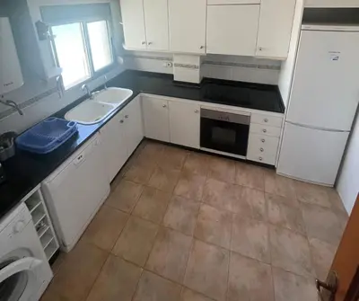 a kitchen with white cabinets and a sink and a dishwasher at Apartamento Rey I in Valencia