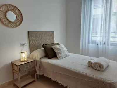 a bedroom with a bed with a mirror and a table at Vistas al mar en Canet Playa WIFI in Canet de Berenguer