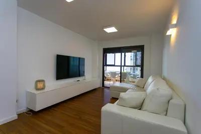 a living room with a white couch and a flat screen tv at Cullera Beach Apartment Espacio in Cullera