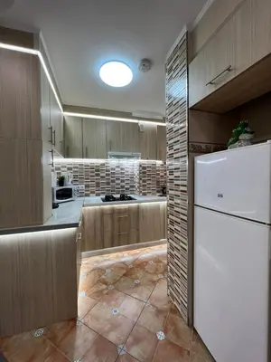 a kitchen with wooden cabinets and a white refrigerator at Peset 69 in Valencia