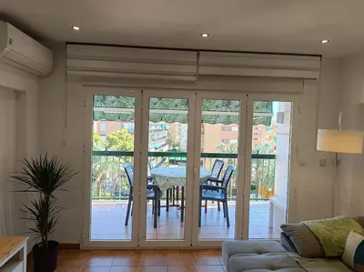 a living room with sliding glass doors with a table and chairs at Beach Nice Flat in Playa Pobla de Farnals