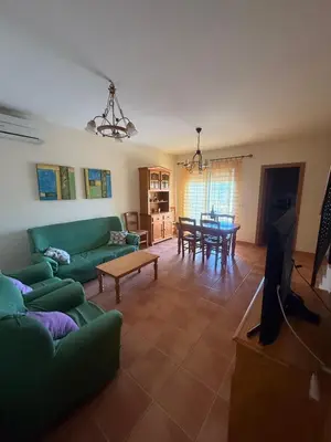 a living room with a green couch and a table at Duplex en Navajas (Castellón) in Navajas
