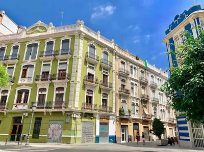 a large yellow building on the side of a street at Heart of trendy area of Russafa with lovely terrace ! au coeur de Ruzafa avec belle terrasse ! in Valencia