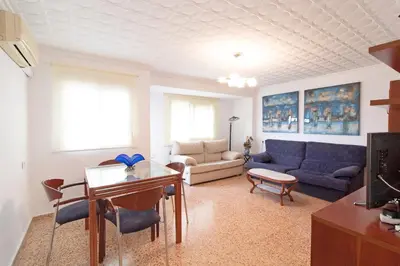 a living room with a couch and a table at Global Vacacional, Apartamento céntrico en Puerto de Sagunto para 5 personas in Puerto de Sagunto