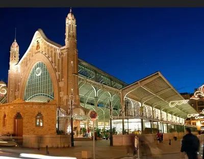 a large brick building with a clock tower at night at centrico cerca al ayuntamiento+luminoso+acogedor in Valencia