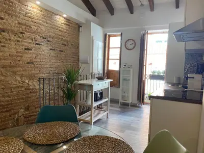 a kitchen with a table and chairs and a brick wall at Hermoso flat de playa in Valencia