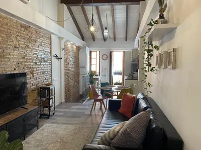 a living room with a couch and a brick wall at Hermoso flat de playa in Valencia
