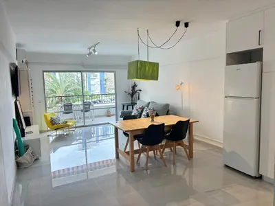 a kitchen and dining room with a table and chairs at Apt. En la Playa, Wifi rápido y piscina. in Puebla de Farnals