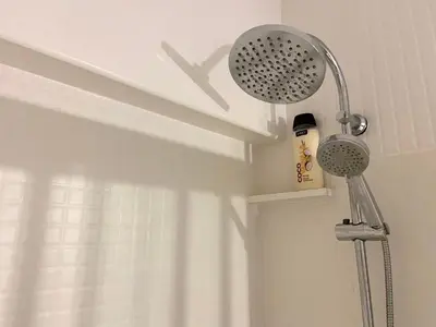 a shower head in a bathroom next to a window at Apt. En la Playa, Wifi rápido y piscina. in Puebla de Farnals