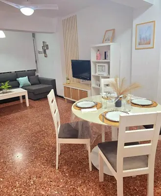 a living room with a table and chairs and a couch at Amplio apartamento in Puebla de Farnals