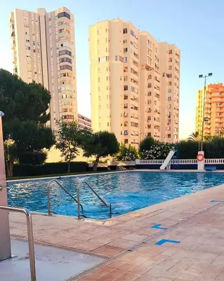 a swimming pool in a city with tall buildings at Amplio apartamento in Puebla de Farnals